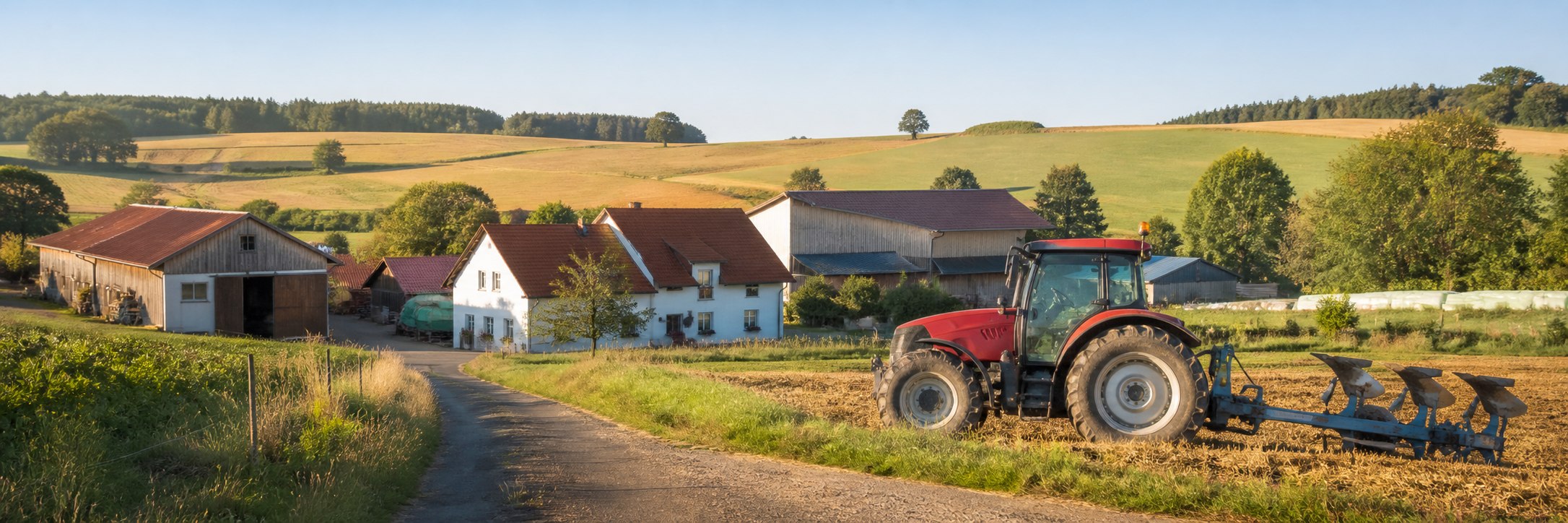 Bewirtschafteter Agrarbetrieb mit Hofstelle, Feldern und rotem Traktor
